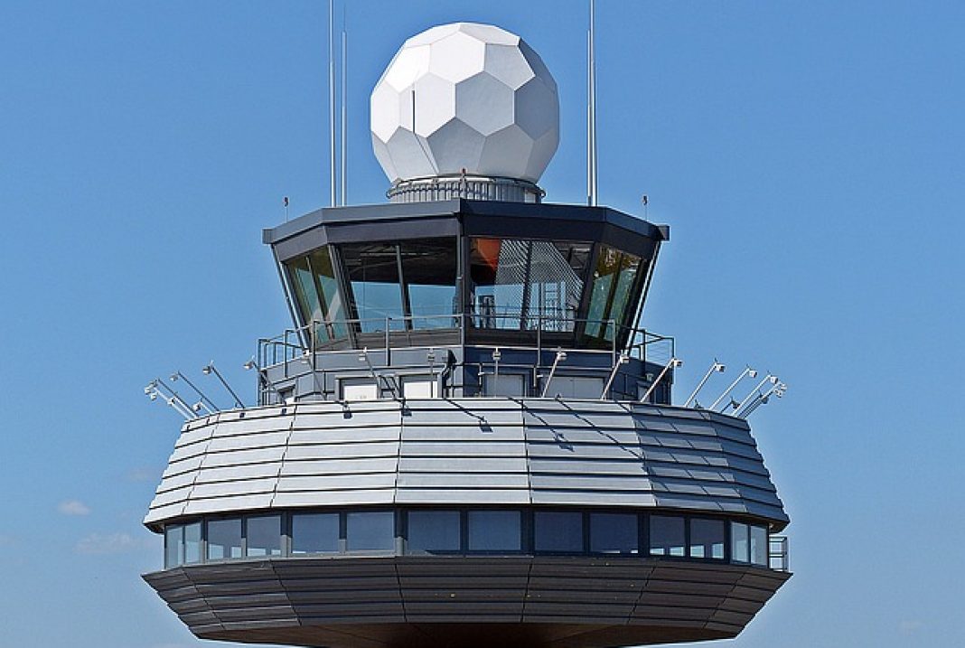 A plane on a runway with a tower in the background photo – Free Schiphol  (ams) Image on Unsplash